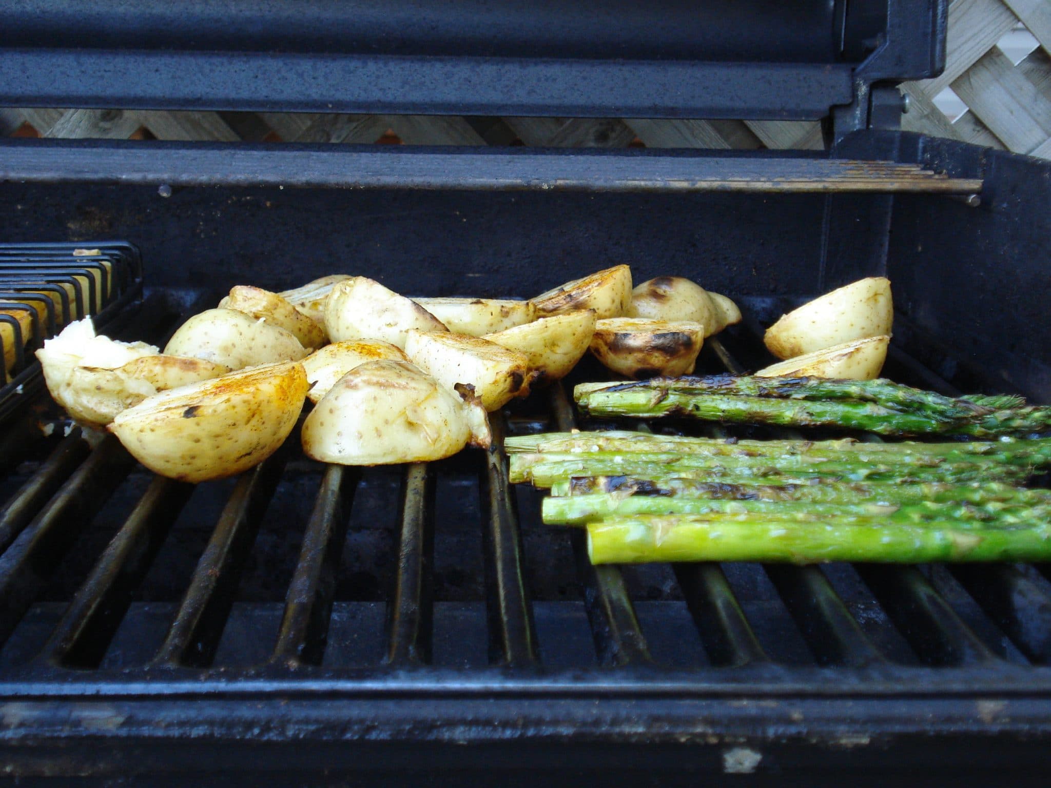 Sliced potato and asparagus on grill