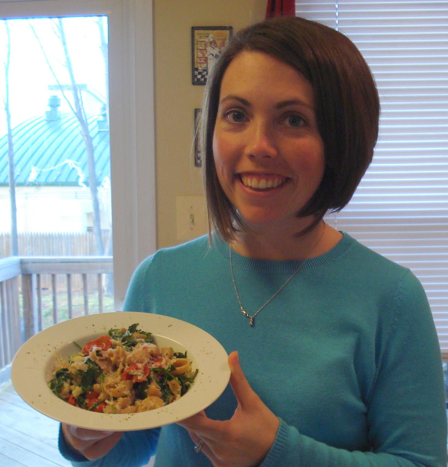 Woman holding plate of Pasta with Roasted Cauliflower and Arugula