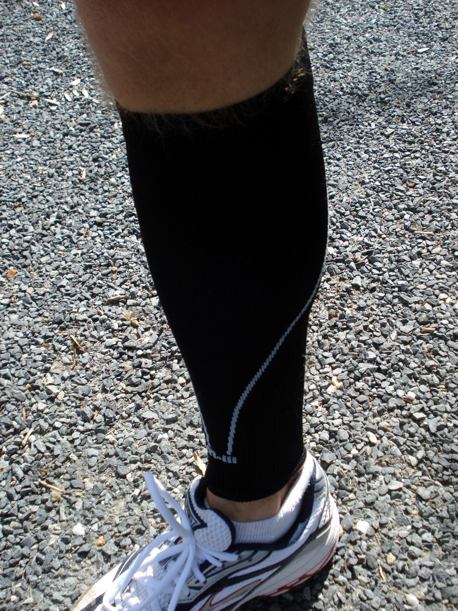 Image of leg wearing black compression sock and white sneaker