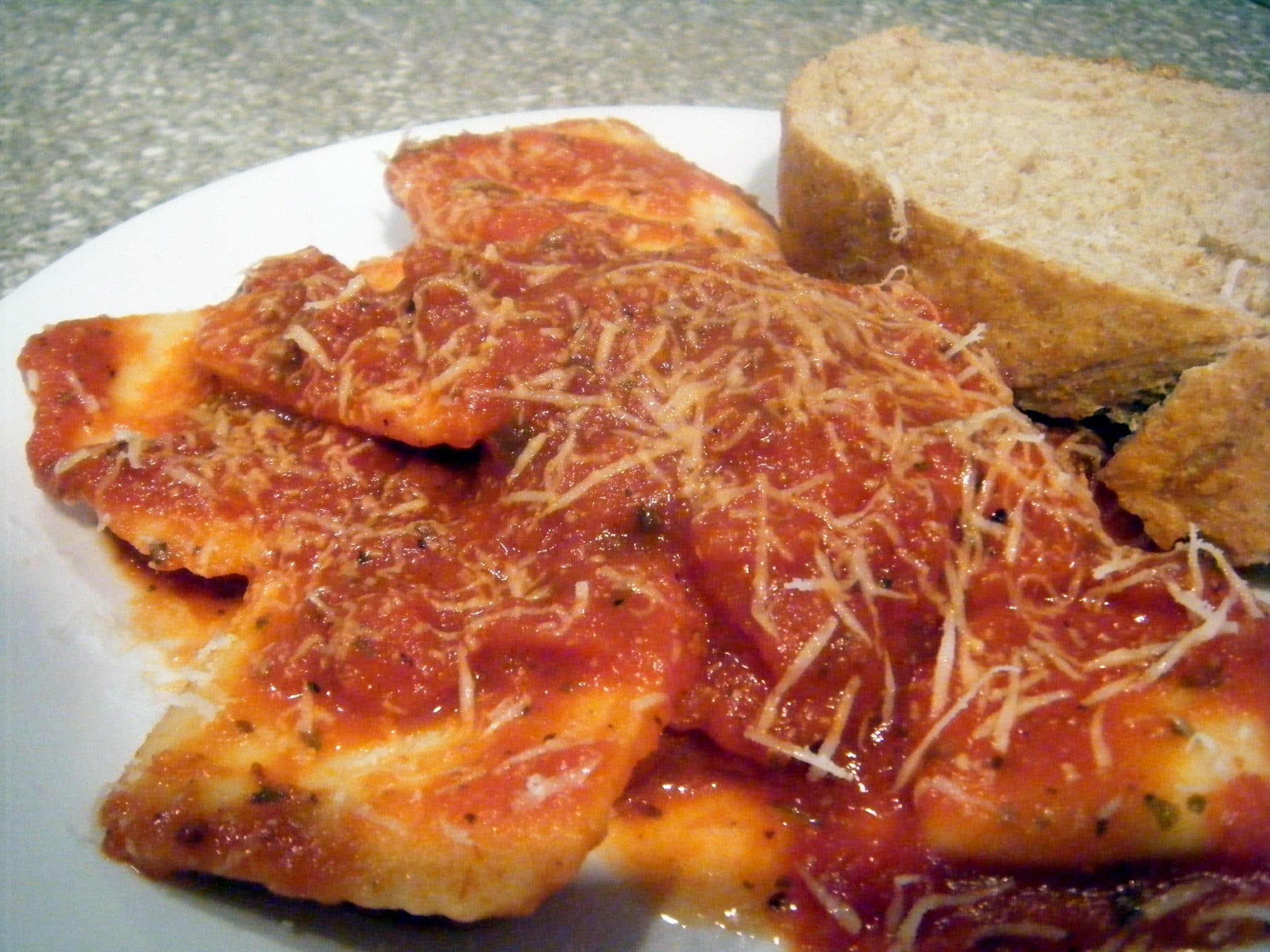 Frozen cheese ravioli on a plate with bread